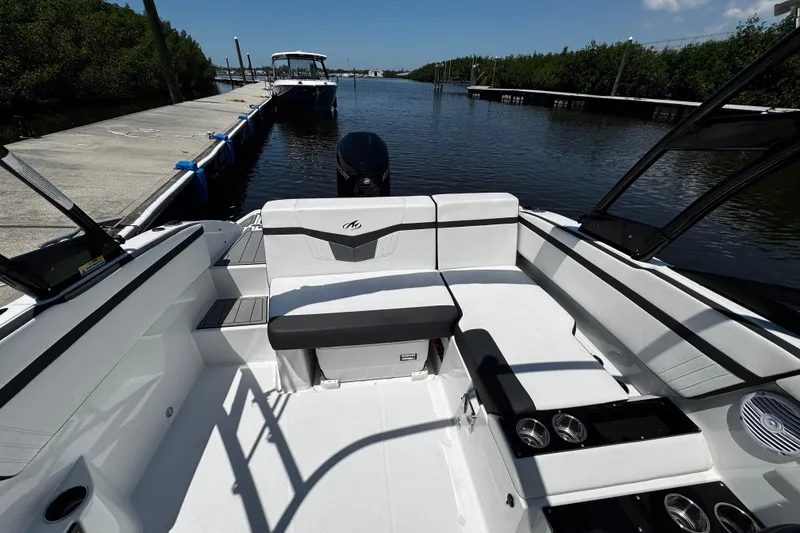 Slide: The Image of 2021 Monterey M225 boat interior at dock, featuring sleek seating and modern design. - 20