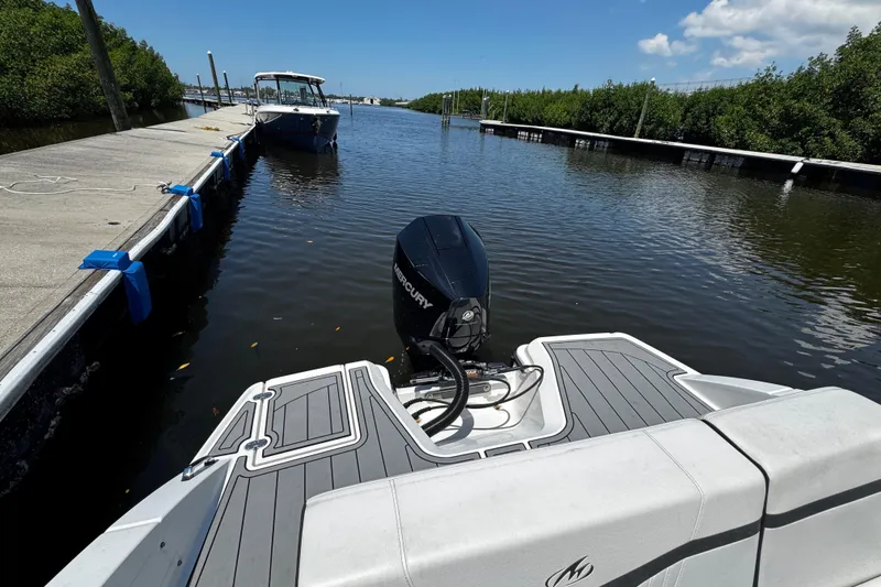 Slide: The Image of 2021 Monterey M225 boat docked on a sunny day with Mercury outboard motor. - 21