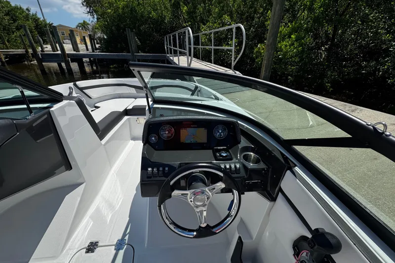 Slide: The Image of 2021 Monterey M225 boat interior with modern dashboard and steering wheel at dock. - 25