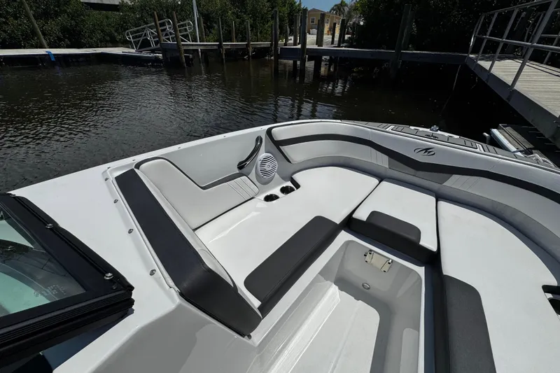 Slide: The Image of 2021 Monterey M225 boat interior with sleek seating and storage, docked by the water. - 26