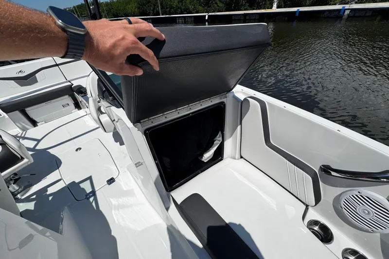 Slide: The Image of 2021 Monterey M225 boat interior with open storage compartment by the water. - 28