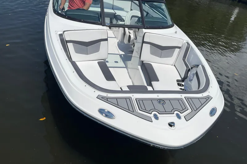 Slide: The Image of 2021 Monterey M225 boat with sleek white design and spacious seating on calm water. - 6