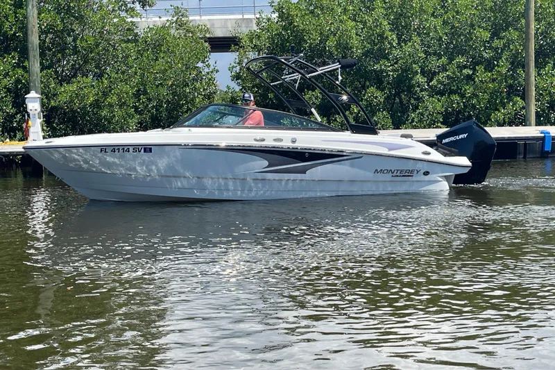 Slide: The Image of 2021 Monterey M225 boat on water, featuring sleek design and Mercury outboard engine. - 8