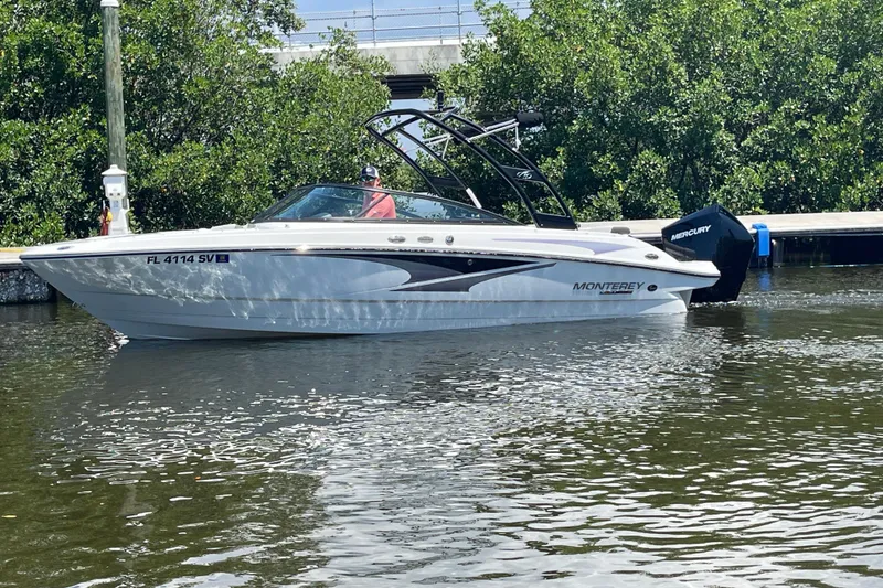 Slide: The Image of 2021 Monterey M225 boat on water, surrounded by lush greenery. - 9