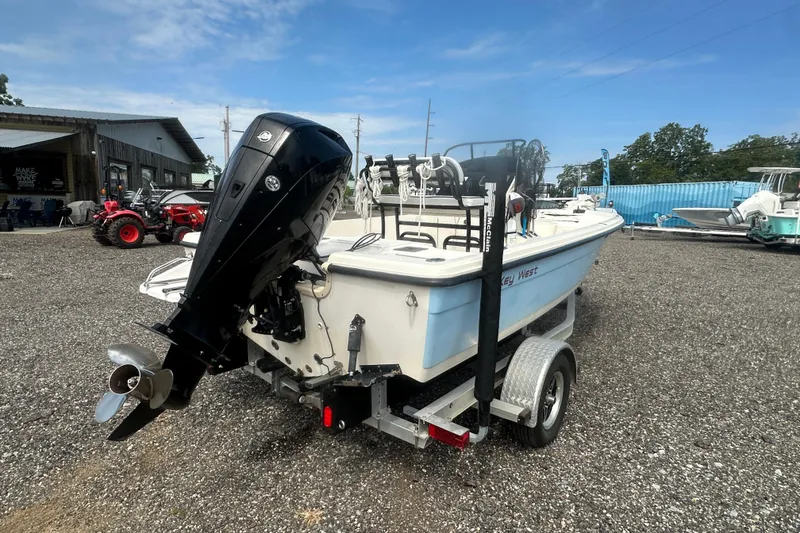 Slide: The Image of 2003 Key West 196 Bay Reef boat on trailer with outboard motor in a gravel lot. - 5