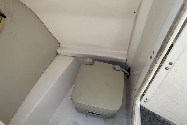 Slide: The Image of 2008 Chaparral Sunesta 224 boat interior with portable toilet in compact space. - 21