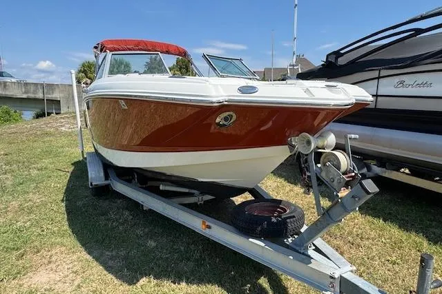 Slide: The Image of 2008 Chaparral Sunesta 224 boat on trailer, red and white, parked on grass. - 3