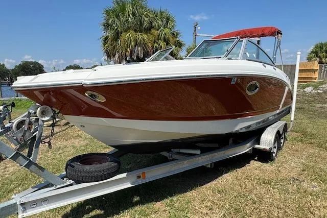 Slide: The Image of 2008 Chaparral Sunesta 224 boat on trailer, red and white design, parked on grass. - 5