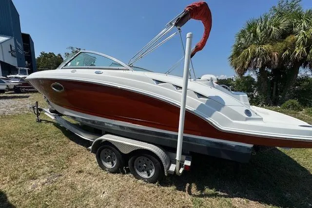 Slide: The Image of 2008 Chaparral Sunesta 224 boat on trailer, red and white, parked on grass. - 7