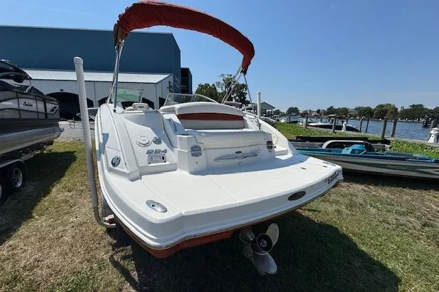 Slide: The Image of 2008 Chaparral Sunesta 224 boat with red canopy, parked on grass near water. - 9