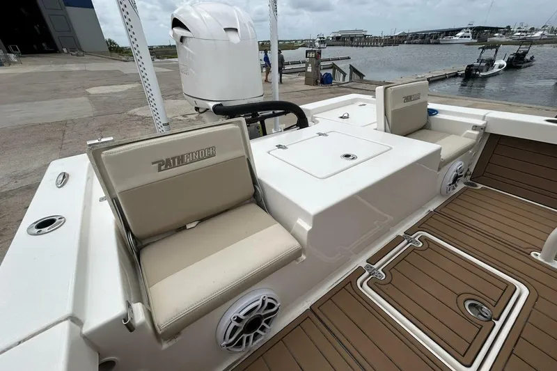 Slide: The Image of 2021 Pathfinder 2400 TRS boat interior with seating and deck, dockside view. - 12