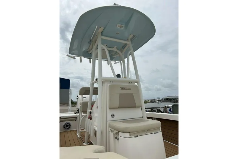 Slide: The Image of 2021 Pathfinder 2400 TRS boat with T-top and seating, docked under cloudy skies. - 6