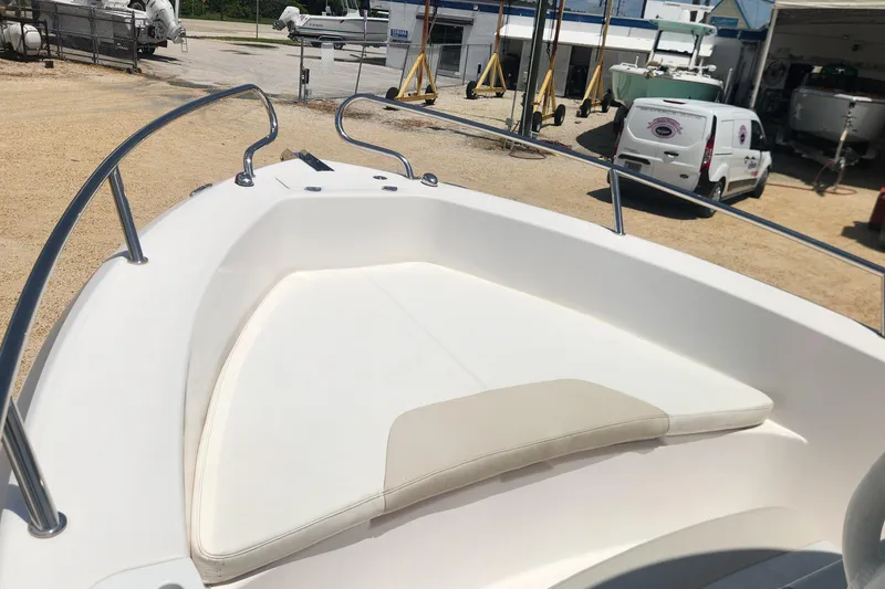 Slide: The Image of Bow seating area of a 2011 Everglades 230CC boat in a marina setting. - 11
