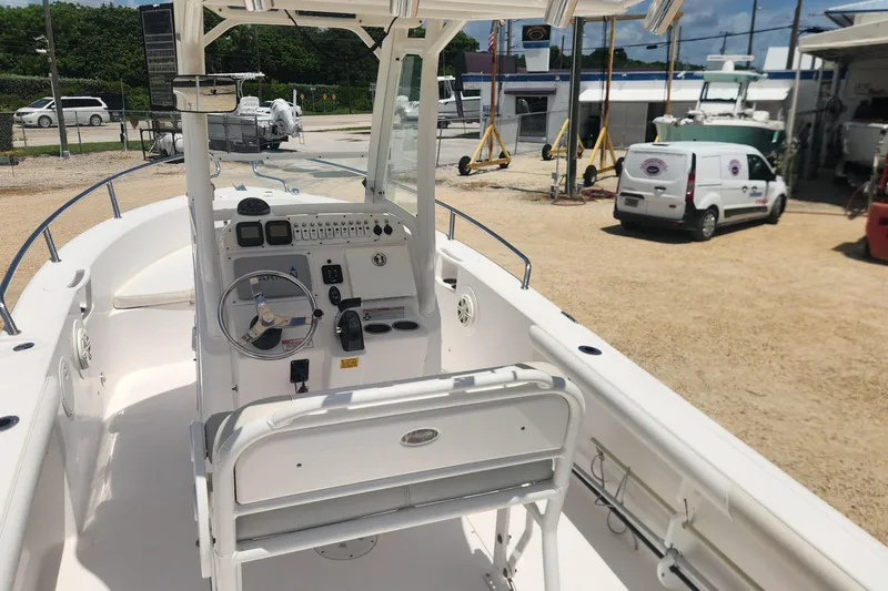 Slide: The Image of 2011 Everglades 230CC boat interior with steering console and controls, parked outdoors. - 7