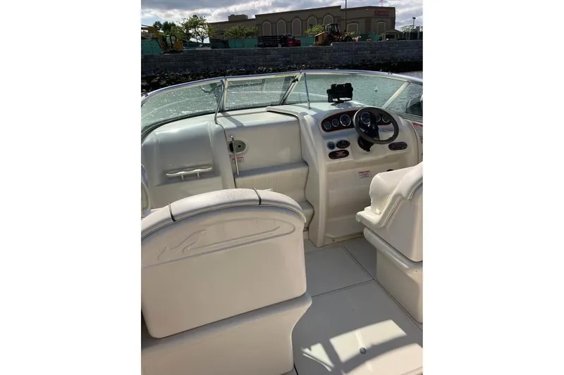 Slide: The Image of 2004 Sea Ray 215 Weekender boat interior with steering wheel and seating. - 3