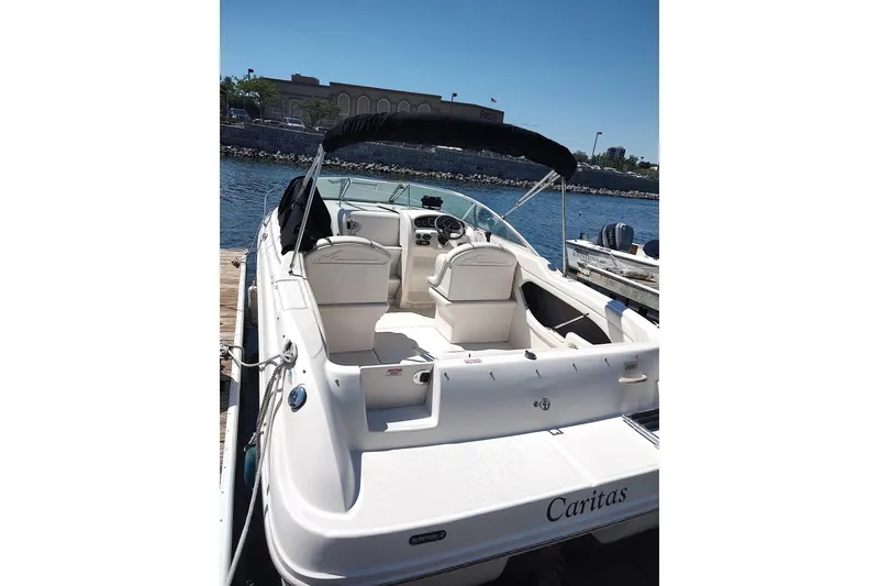 Slide: The Image of 2004 Sea Ray 215 Weekender boat docked, featuring spacious seating and sleek design. - 7