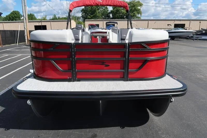 Slide: The Image of 2026 Bennington S Quad Bench 20 SSR pontoon boat, red exterior, parked outdoors. - 3