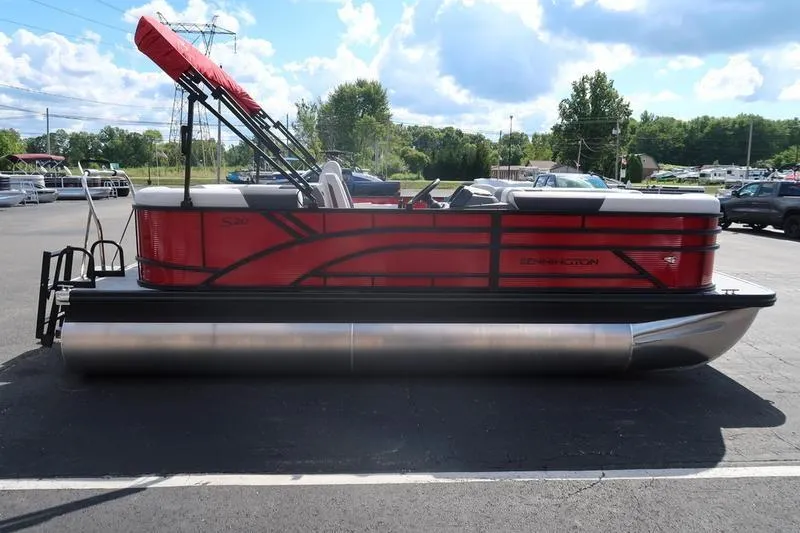 Slide: The Image of 2026 Bennington S Quad Bench 20 SSR pontoon boat with red exterior, parked outdoors. - 6