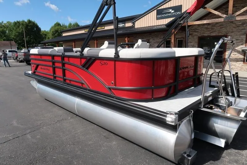 Slide: The Image of 2026 Bennington S Quad Bench 20 SSR pontoon boat, red exterior, parked outdoors. - 9