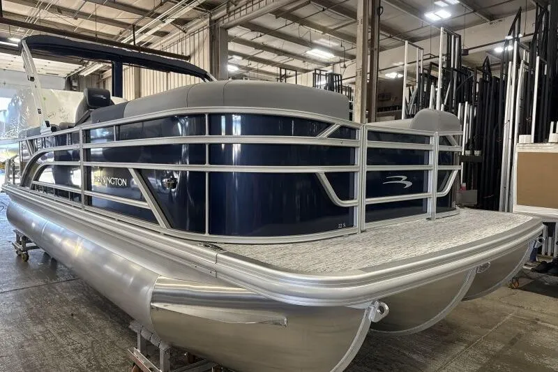 Slide: The Image of 2026 Bennington 22 SSRSE pontoon boat in a warehouse setting. - 2