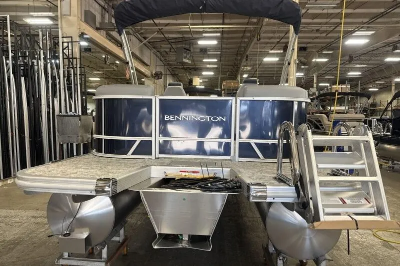 Slide: The Image of 2026 Bennington 22 SSRSE pontoon boat in a warehouse setting. - 6