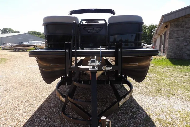 Slide: The Image of 2026 Bennington M Swingback 24 MSB pontoon boat on a trailer, parked outdoors. - 3