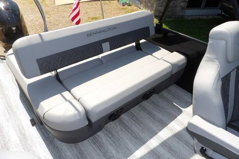 Slide: The Image of 2026 Bennington M Swingback 24 MSB boat interior with gray seating and American flag. - 33