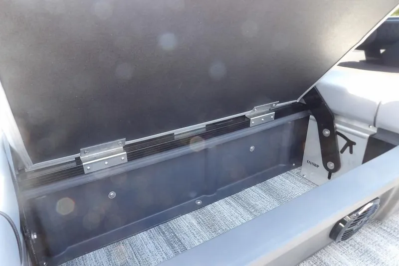 Slide: The Image of 2026 Bennington M Swingback 24 MSB storage compartment with open lid and carpeted interior. - 37