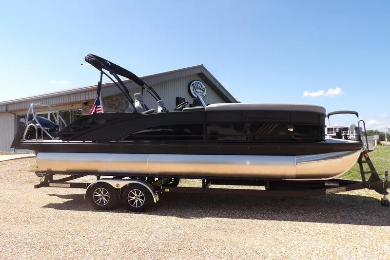 Slide: The Image of 2026 Bennington M Swingback 24 MSB pontoon boat on trailer, parked outdoors. - 4