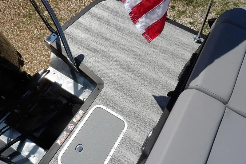 Slide: The Image of 2026 Bennington M Swingback 24 MSB boat deck with gray flooring and American flag. - 44