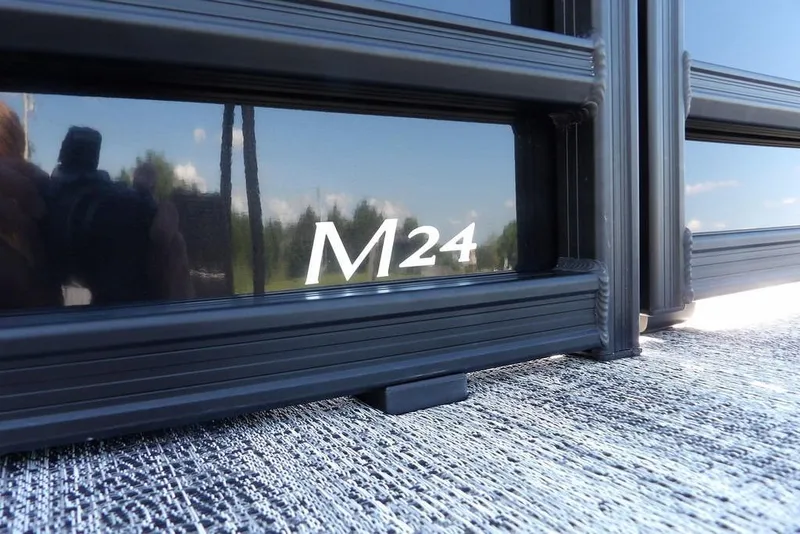 Slide: The Image of 2026 Bennington M Swingback 24 MSB, close-up of "M24" logo on sleek black surface. - 48