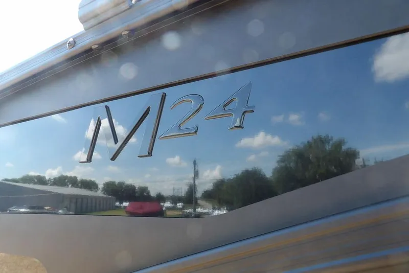 Slide: The Image of 2026 Bennington M Swingback 24 MSB boat with reflective exterior and sky reflection. - 50