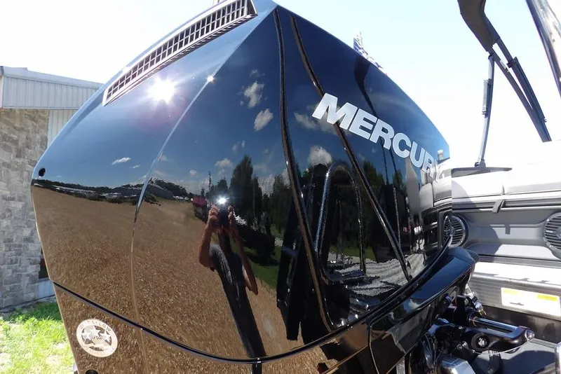 Slide: The Image of 2026 Bennington M Swingback 24 MSB with Mercury engine, reflecting sunny outdoor scene. - 55