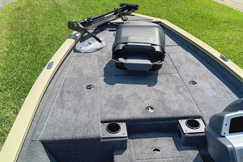 Slide: The Image of 2026 Tracker Pro Team 175 boat deck with seating and trolling motor, on grass. - 10