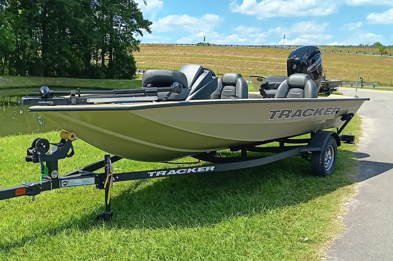 Slide: The Image of 2026 Tracker Pro Team 175 boat on trailer, parked on grass by a pond. - 4