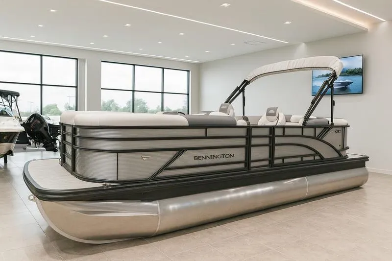 Slide: The Image of 2026 Bennington S Quad Bench 22 SSR pontoon boat in showroom, sleek design, modern interior. - 1