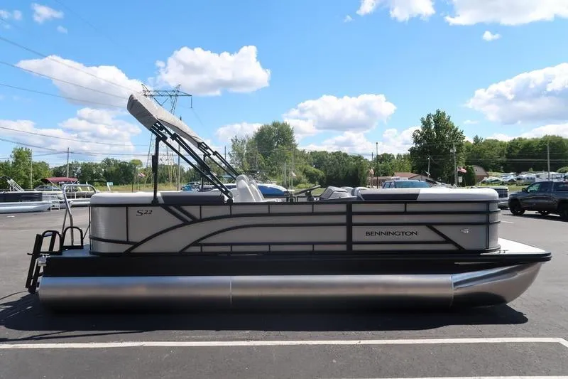 Slide: The Image of 2026 Bennington S Quad Bench 22 SSR pontoon boat under a clear blue sky. - 12
