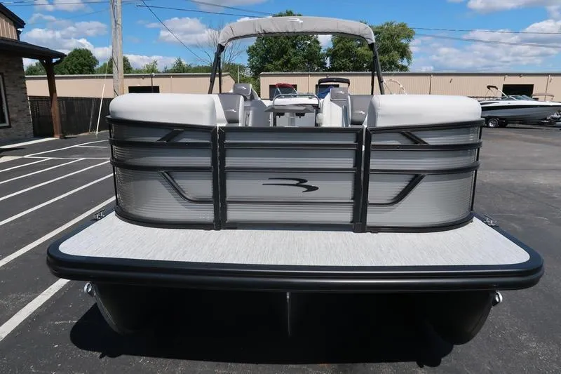 Slide: The Image of 2026 Bennington S Quad Bench 22 SSR pontoon boat, rear view in parking lot. - 14