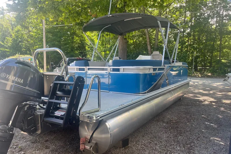 Slide: The Image of 2026 Avalon 23 LSZ Quad Lounger pontoon boat with Yamaha motor, parked outdoors. - 7