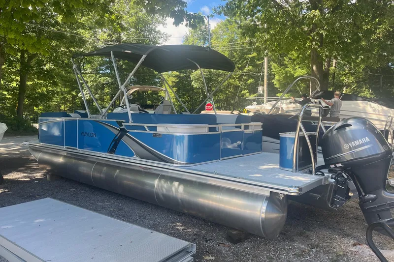 Slide: The Image of 2026 Avalon 23 LSZ Quad Lounger pontoon boat with Yamaha motor, parked under trees. - 9