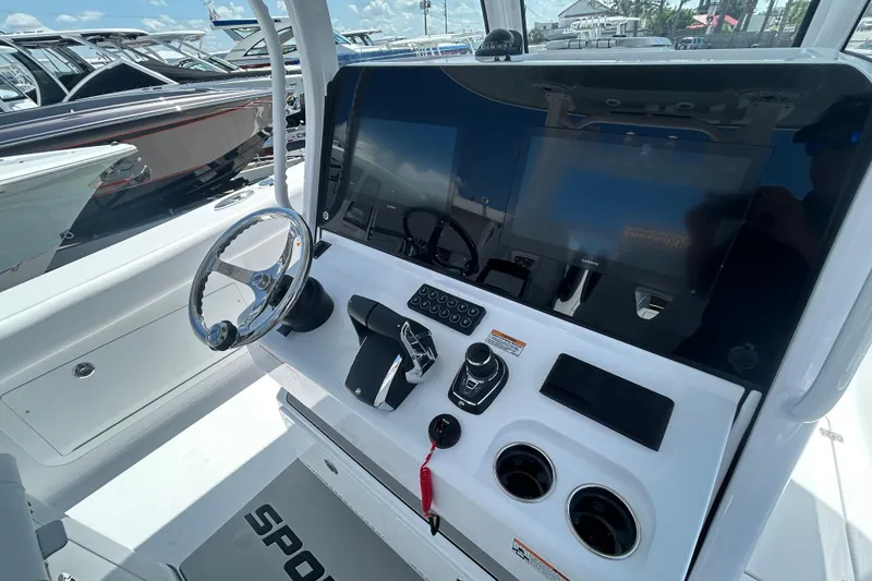 Slide: The Image of 2026 Sportsman Heritage 321 Center Console boat dashboard with steering wheel and controls. - 8