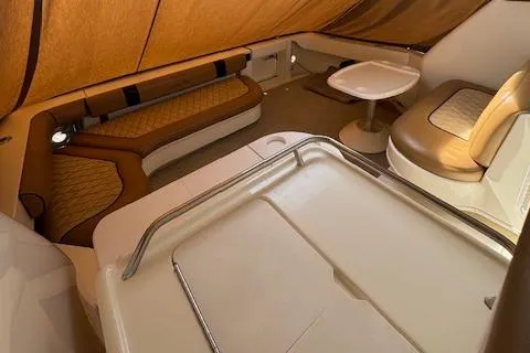 Slide: The Image of 2001 Sea Ray 340 Amberjack interior with seating and table, featuring tan and brown upholstery. - 16