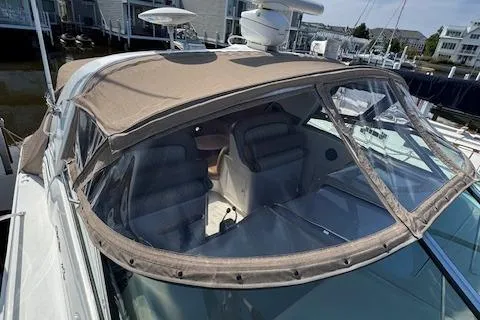 Slide: The Image of 2001 Sea Ray 340 Amberjack boat with beige canopy and clear windows at marina. - 19