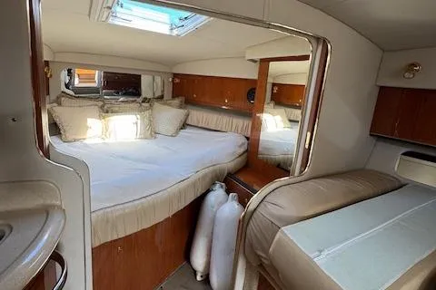 Slide: The Image of 2001 Sea Ray 340 Amberjack cabin interior with bed, skylight, and wooden cabinetry. - 22