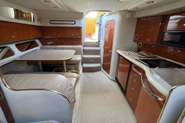 Slide: The Image of Interior of 2001 Sea Ray 340 Amberjack yacht with kitchen and dining area. - 24