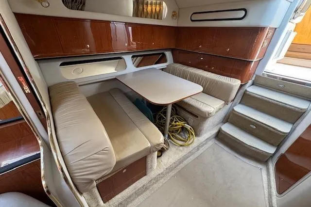 Slide: The Image of 2001 Sea Ray 340 Amberjack cabin interior with seating, table, and wooden cabinetry. - 26