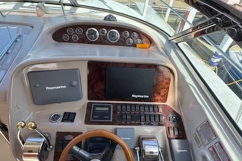 Slide: The Image of 2001 Sea Ray 340 Amberjack helm with Raymarine electronics and wood-accented dashboard. - 5