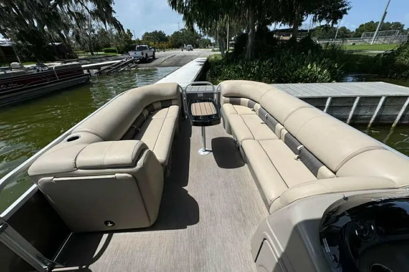 Slide: The Image of 2024 Sun Tracker Party Barge 24 DLX with spacious seating and modern design at a dock. - 2