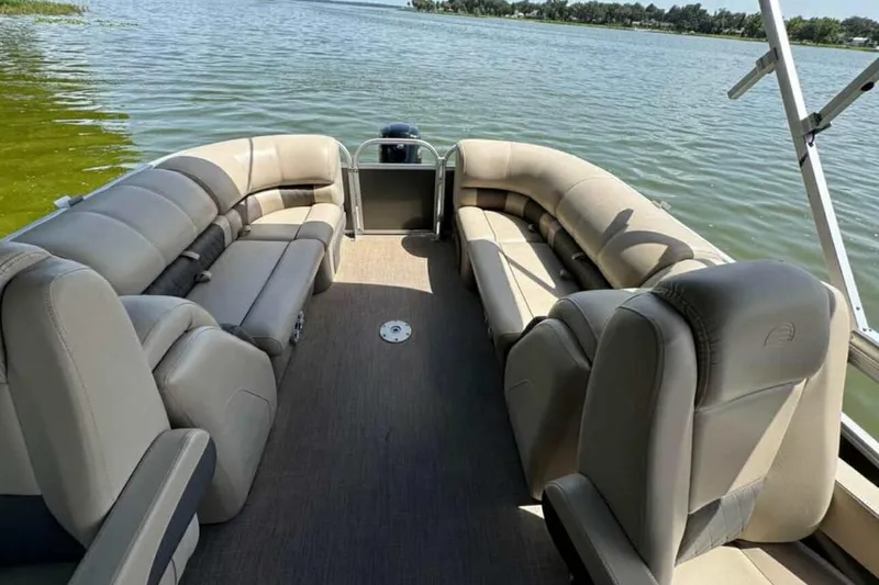 Slide: The Image of 2024 Sun Tracker Party Barge 24 DLX pontoon boat interior with spacious seating on a lake. - 4
