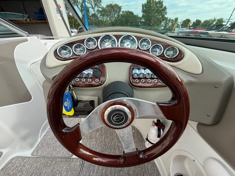 Slide: The Image of Steering wheel and dashboard of 2012 Crownline 225 SS boat, featuring gauges and controls. - 15